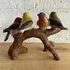 Figura De 4 Pájaros Posados Sobre Un Tronco